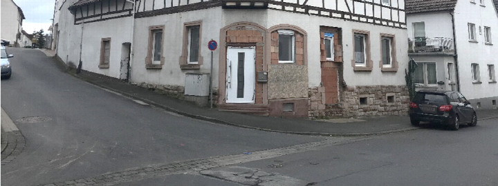 Eckhaus mit Fachwerkfassade und weißer Haustür an der Hauptstraße 14 in Alzenau-Hörstein, Ansicht von der Straße