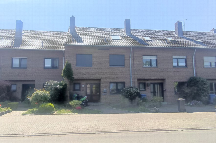 Frontansicht eines Reihenhauses in Hamminkeln, Danziger Straße 15, mit Ziegelfassade, Dachgauben und Vorgarten