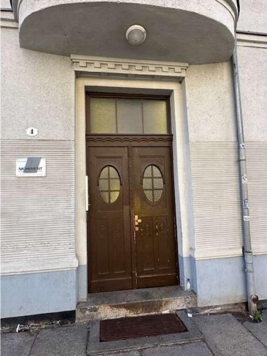 Eingangstür eines Gebäudes mit braunen Doppeltüren, ovalem Fenster, Überdachung und Hausnummer 4 an der Gießerstraße 4 in Chemnitz