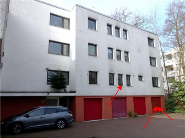 Fassade eines Mehrfamilienhauses mit roten Garagentoren und Fenstern, geparktes Fahrzeug vorne links, Dorsten, Barkenberger Allee 1a