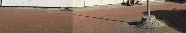 Pflastersteinfläche neben einer Betonwand mit Graffiti und einem Mastfuß, Außenansicht einer Seite des Gebäudes in Hannover