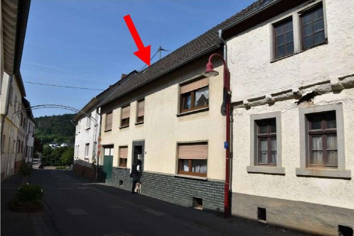Fassade eines Einfamilienhauses in Hönningen, Hauptstraße 21 1, mit Dach, Fenstern und Eingangsbereich unter klarem Himmel