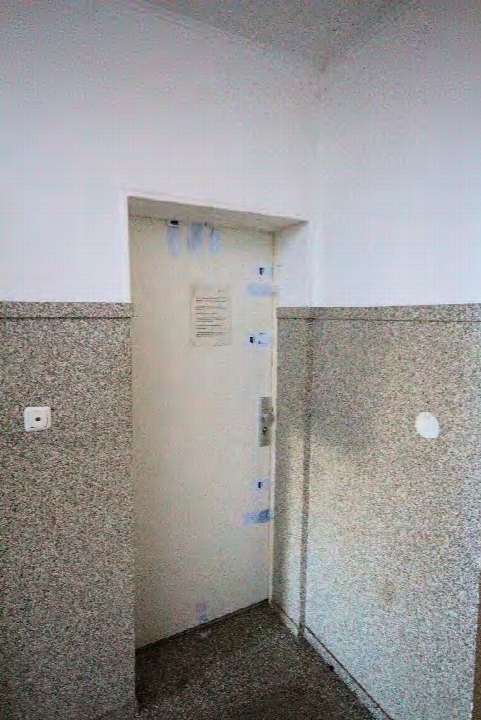 Innenansicht eines Flurs mit Tür, teilweise verkleideten Wänden und Lichtschalter im Mehrfamilienhaus Rossheidestrasse 81, Gladbeck