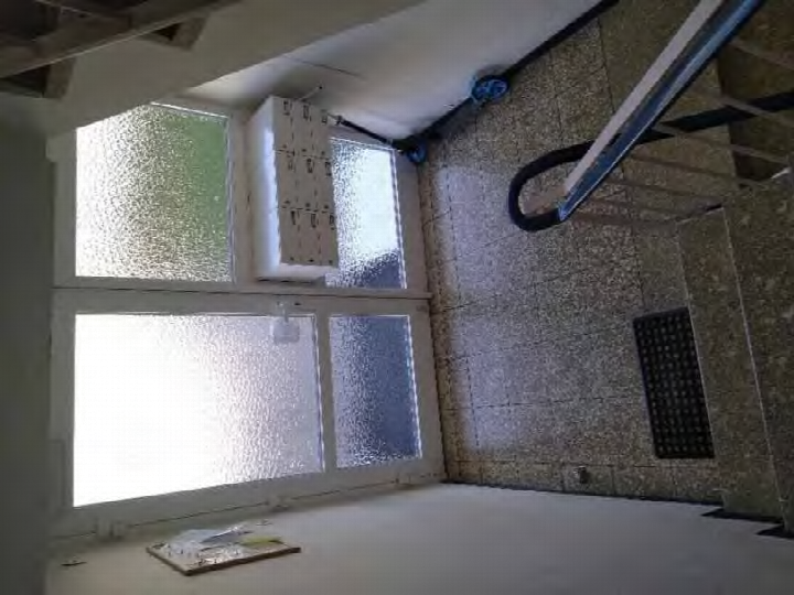 Innenraum mit rauchglasfenstern, sichtbaren Deckenbalken und unverputzten Wänden, vermutlich technischer Raum