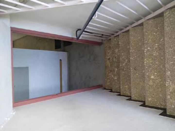 Unfertiger Keller mit Betonwänden, glattem Boden und Metalldeckenkonstruktion, rote Türumrandung sichtbar