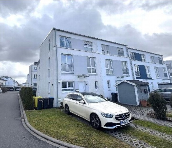 Vorderansicht eines Reihenhauses in Dreieich, Erich-Scheid-Str. 15, mit geparktem Auto und Vorgarten