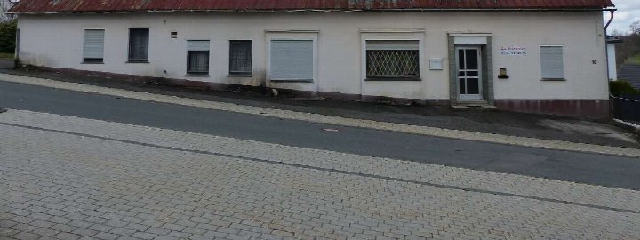 Seitenansicht eines weißen Gebäudes mit rotem Dach und Fenstern an der Marienstraße 10 in Wenden, Gewerbegrundstück