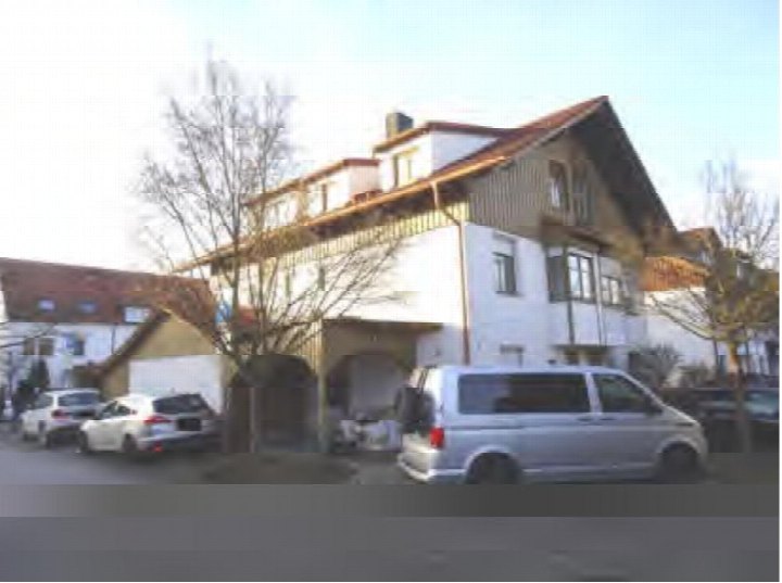 Außenansicht eines Gebäudes mit Garage und geparkten Fahrzeugen in Neufahrn b. Freising, Sudetenweg 16