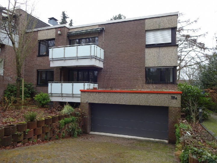 Vorderansicht eines Mehrfamilienhauses mit Balkonen, Einfahrt zur Garage und Vorgarten in Bochum, Laerholzstr. 59