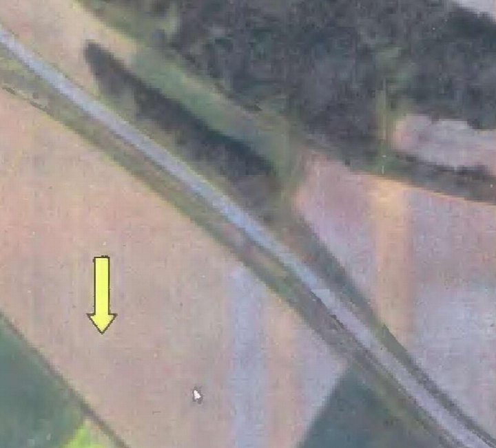 Luftbildansicht von Grundstücken und Feldern mit markierter Stelle durch gelben Pfeil in Hohenreichen