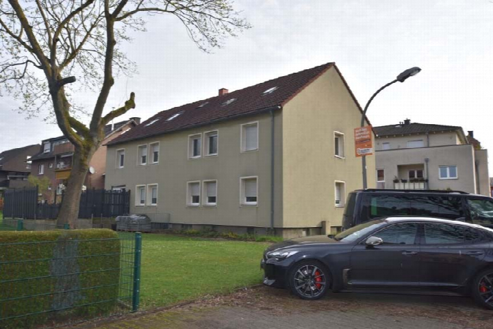 Seitenansicht eines zweistöckigen Reihenhausanteils mit braunem Dach, Fenstern und angrenzendem Grünbereich in Bönen, Am Südberg 51