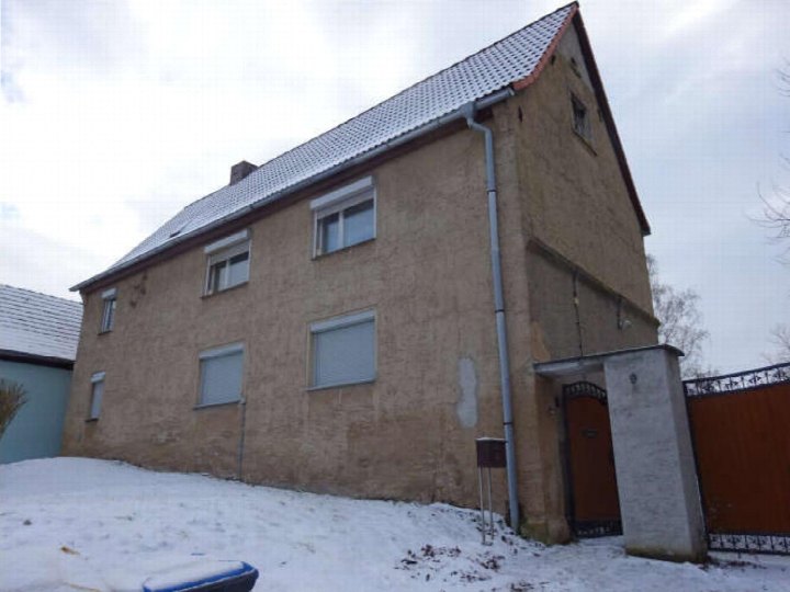 Seitenansicht eines zweistöckigen Wohnhauses in Teuchern, Mathias-Vogler-Straße 9, mit Schneebedecktem Grundstück und Einfahrtstor