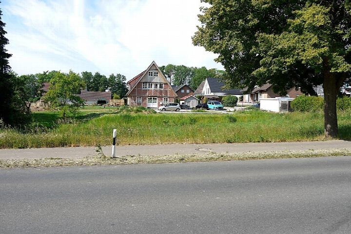 Grünes Grundstück mit Gras und Bäumen, im Hintergrund Wohnhäuser in Hüllhorst, Ortsteil Tengern