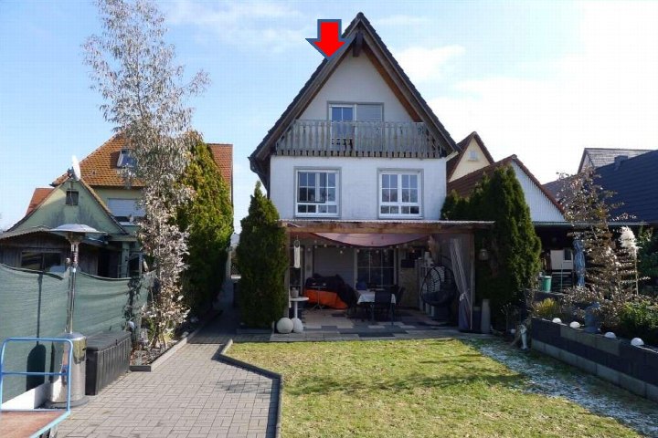 Vorderansicht eines Einfamilienhauses mit Dachgaube, Balkon und Vorgarten in Henfenfeld