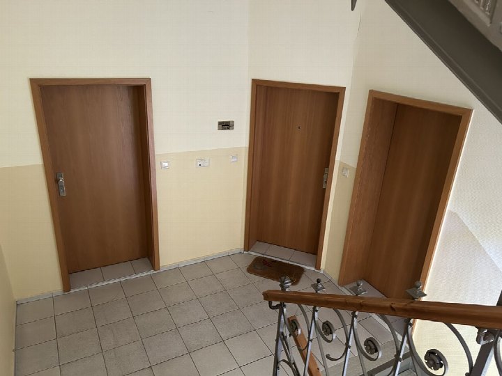 Treppenhaus mit drei Holztüren, Fliesenboden und Metallgeländer im Gebäude Glösaer Straße 28, Chemnitz