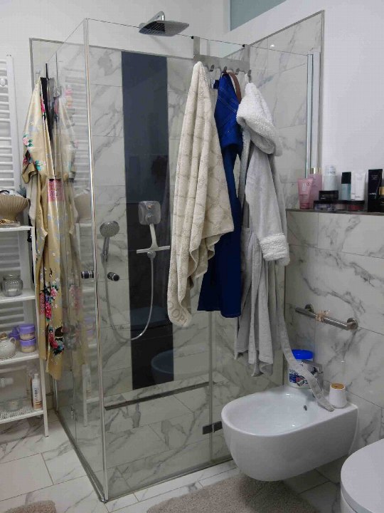 Badezimmer mit Dusche, Waschbecken und Toilette, Marmorfliesen, Handtücher und Badzubehör im Raum Berlin 12587