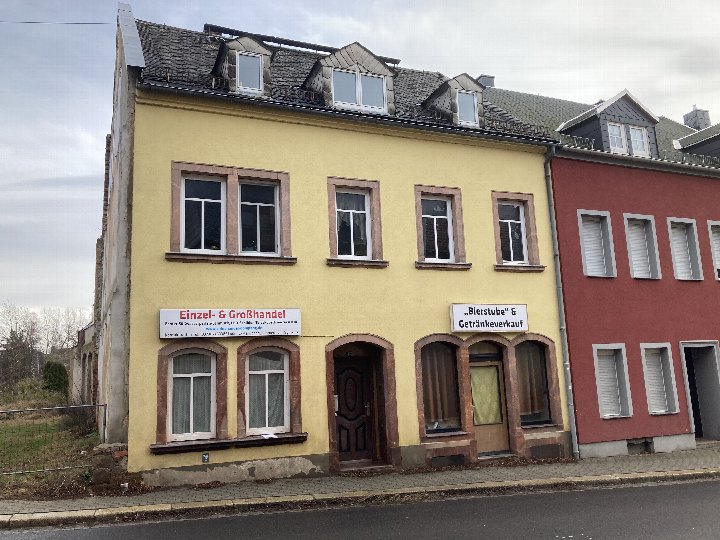 Gelbes Wohn- und Geschäftshaus mit Schildern für Einzel- und Großhandel sowie Bierstube, Leipziger Str. 47, Geringswalde