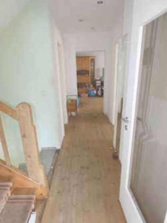 Innenansicht eines Flurs mit Holztreppe links und Türen zu weiteren Räumen im Einfamilienhaus Feldstraße 25, Zernsdorf