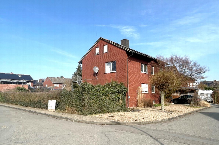 Zweifamilienhaus aus rotem Backstein mit Satteldach, Satellitenschüssel und Vorgarten an der Ecke Uhlenhorst 13 in Nordwalde