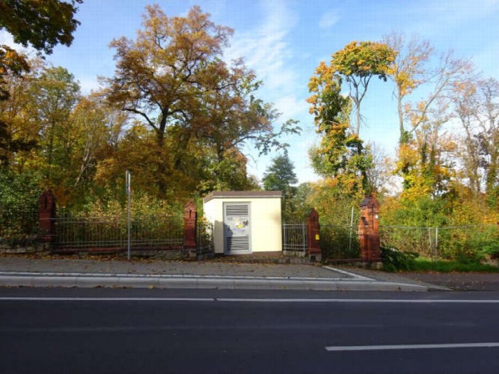Außenansicht eines kleinen technischen Gebäudes am Straßenrand mit Zaun und Herbstbäumen im Hintergrund in Weißenfels, Naumburger Straße 59