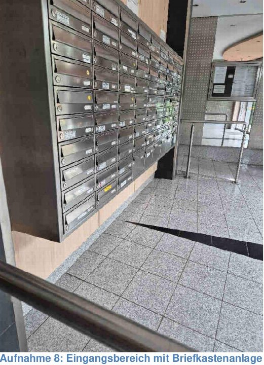 Eingangsbereich mit Briefkastenanlage, gefliestem Boden und Metallgeländern in einem Mehrfamilienhaus
