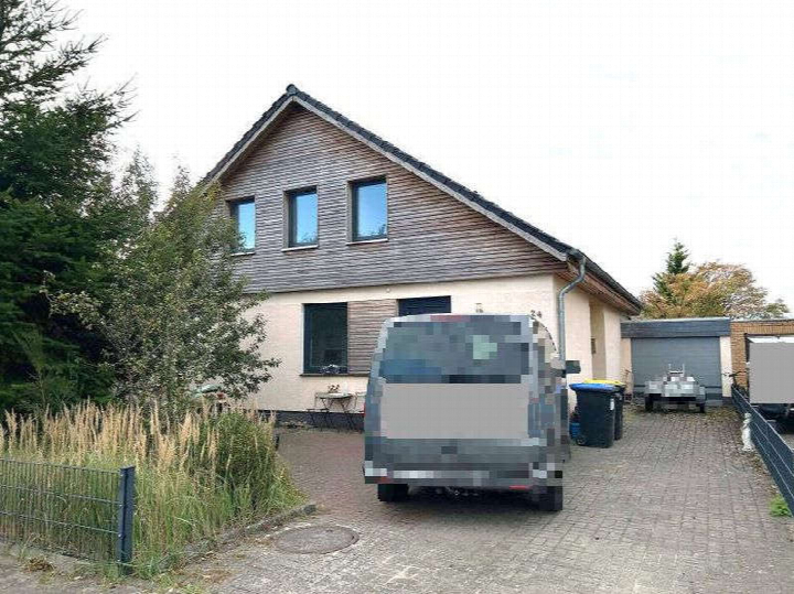 Pflasterfläche mit geparktem Fahrzeug vor einem Gebäude mit Garage und Mülltonnen in Wrestedt, Fischteichsfeld 24