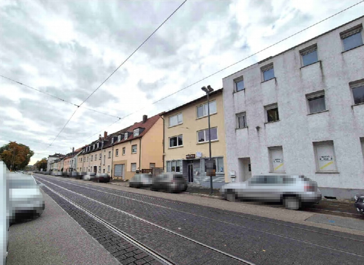 Außenansicht des Wohn- und Geschäftshauses an der Carl-Bosch-Straße 193 in Ludwigshafen-Friesenheim mit Straßenbahnspuren und geparkten Fahrzeugen
