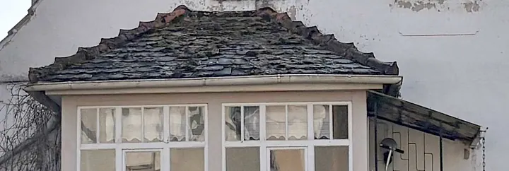 Seitenansicht eines Gebäudes mit Schieferdach, Fenstern und verputzter Fassade in Morschen, Elzestraße 44