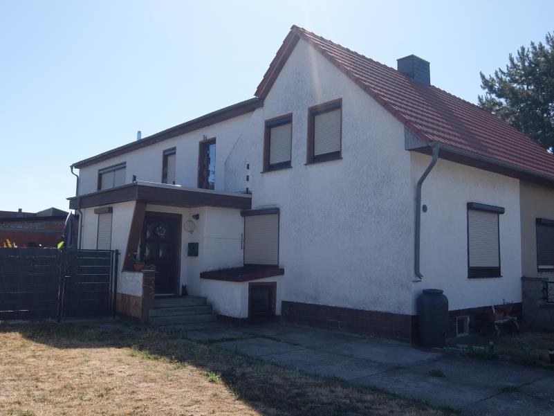 Vorderansicht einer Doppelhaushälfte in Blankenburg, Finkenweg 20, mit weiß verputzter Fassade, rotem Ziegeldach und Eingangsbereich mit Stufen