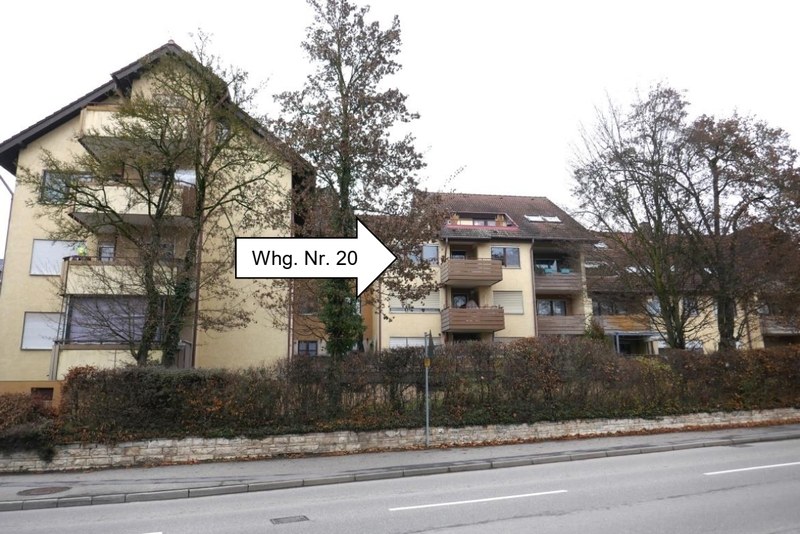 Gebäude in Öhringen, Rendelstraße 23/25, mit markierter Wohnung Nr. 20; mehrstöckige Wohnhäuser mit Balkonen, Bäume und Hecke im Vordergrund, Straße im Vordergrund