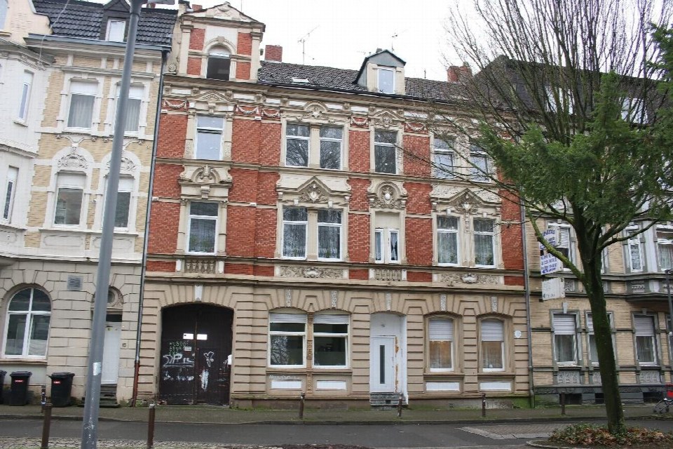 Fassade eines mehrstöckigen Wohnhauses in Gelsenkirchen, Josefstraße 17, mit roten Ziegeln und verzierten Fenstereinfassungen