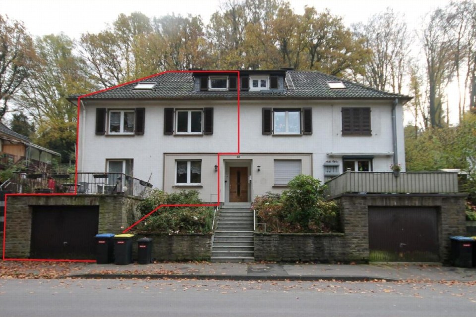 Vorderansicht eines Mehrfamilienhauses mit Satteldach, Eingangstreppe, Balkonen und Garagen an der Ittertalstraße 59 in Solingen