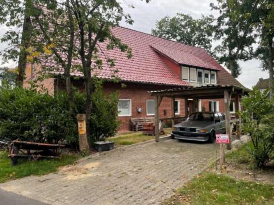 Einfamilienhaus mit rotem Ziegeldach und Backsteinfassade, Vorderansicht mit Carport und gepflastertem Zugangsweg, Haselünne, Schulstr. 7