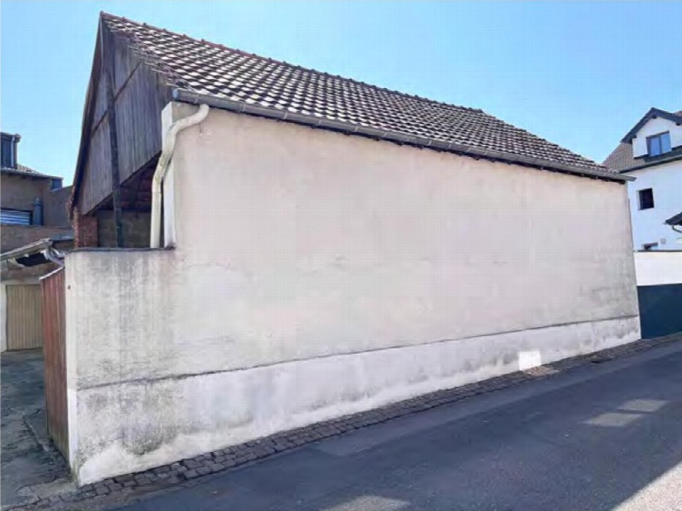 Seitenansicht eines Gebäudes mit Ziegeldach, Putzwand und Regenrohr an der Myhler Straße 83 in Hückelhoven