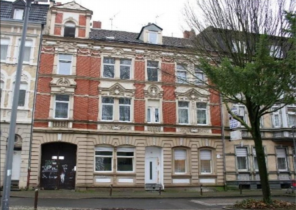 Fassade eines mehrstöckigen Wohnhauses in Gelsenkirchen, Josefstraße 17, mit roten Ziegeln und verzierten Fensterelementen