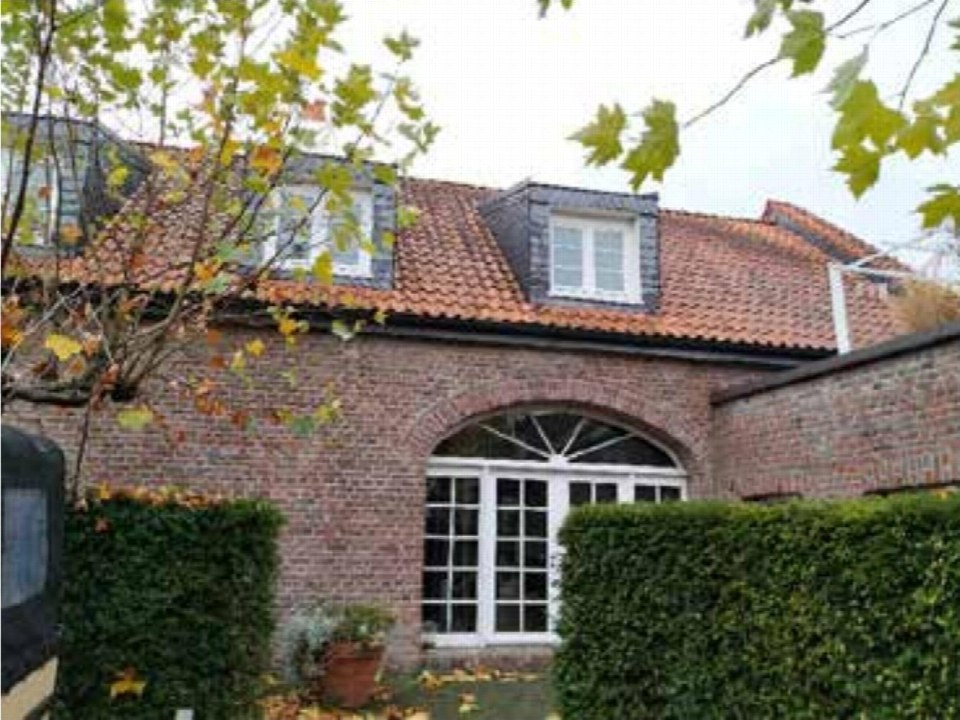Eingangsbereich eines Backsteinhauses mit Bogenfenster, umgeben von Hecken und Herbstlaub, Dorfstraße 51, Meerbusch-Büderich