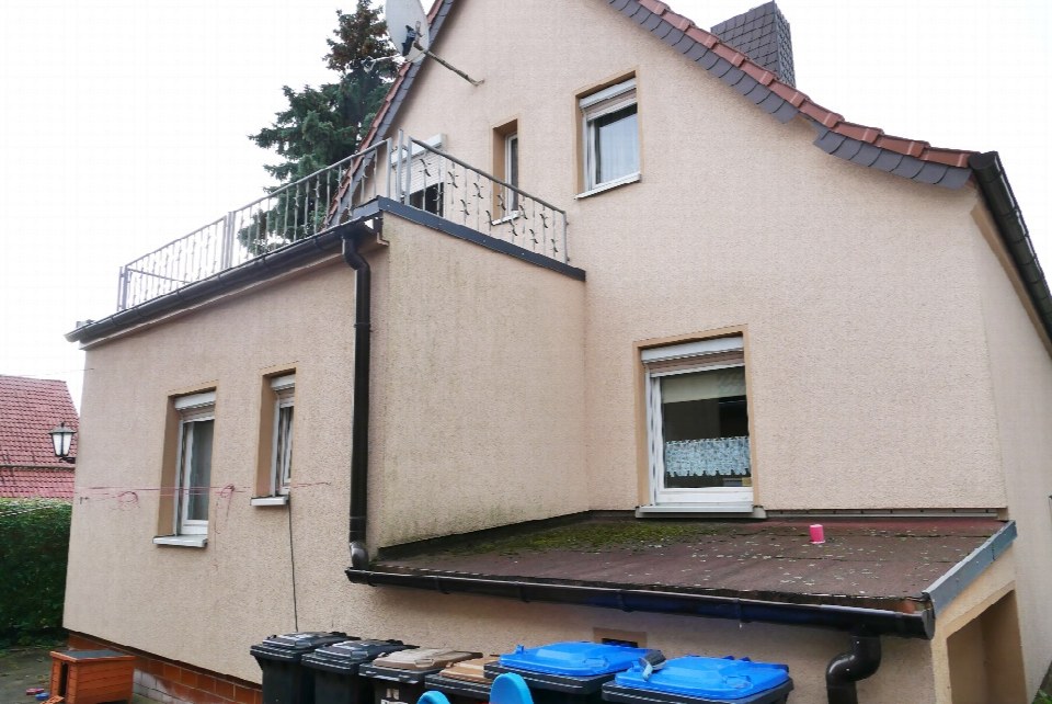 Seitenansicht eines zweistöckigen Wohnhauses mit Balkon, Dach und Fenstern in Wallhausen, Neue Siedlung 6