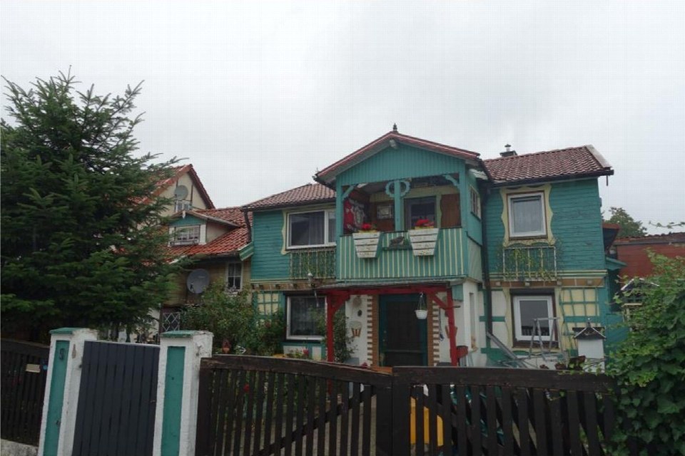 Vorderansicht eines zweistöckigen Holzhauses mit Veranda, Balkon und Gartenzaun, Marienstraße 5, Harztor
