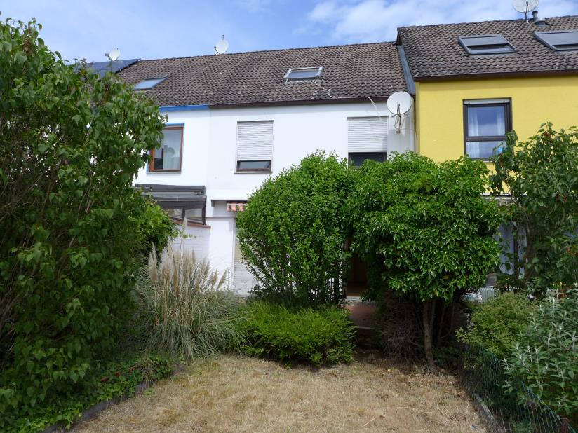 Gartenbereich mit Sträuchern und trockenem Gras vor einem Wohnhaus in Hattersheim, Linsenbergerstraße