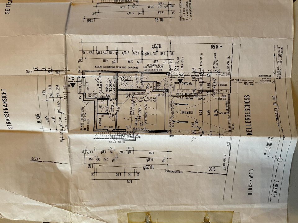 Grundriss des Kellergeschosses mit Einfahrt, Garage, Waschraum und Abstellräumen, inklusive Maßangaben und technischen Details