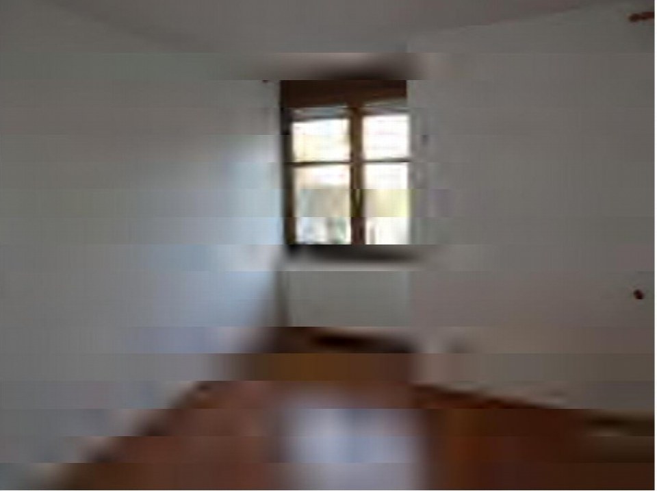Innenraumansicht einer Garage mit Fenster und Holzboden, leicht verschwommen