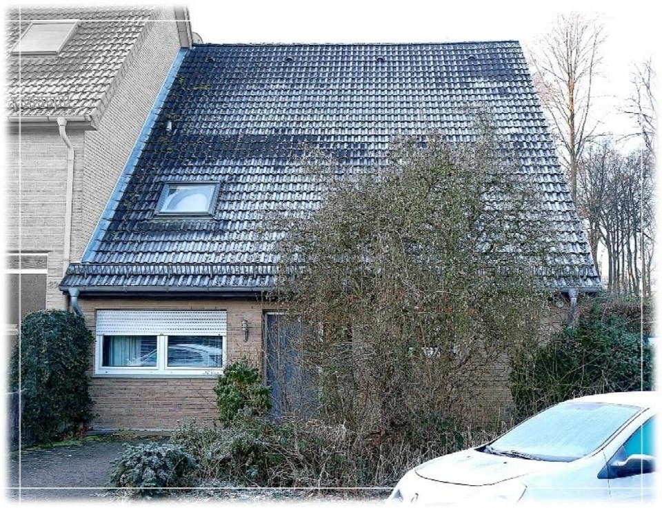 Außenansicht vorne einer Doppelhaushälfte mit Satteldach, Fenster, Eingangstür und Vorgarten in Berlin