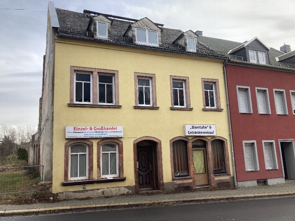 Gelbes Wohn- und Geschäftshaus mit Schildern für Einzel- und Großhandel sowie Bierstube, Leipziger Str. 47, Geringswalde