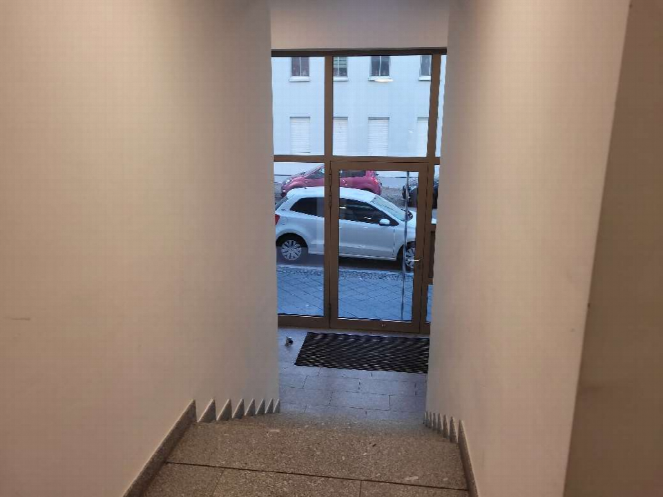 Eingangsbereich mit Treppenstufen und Glastür zur Außentreppe, dahinter geparkte Autos und ein weißes Gebäude in Leipzig, Seelenbinderstraße 13