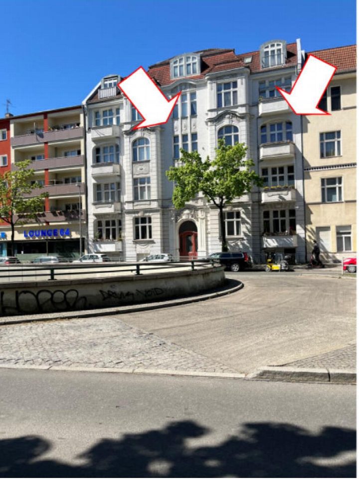 Fassade eines mehrstöckigen Wohngebäudes mit rotem Dach und vielen Fenstern