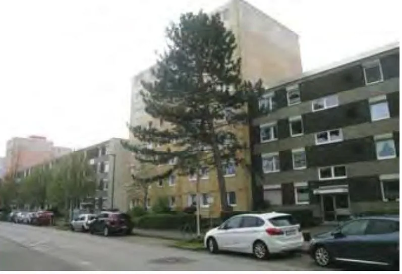 Straßenansicht mit geparkten Fahrzeugen vor mehrstöckigen Wohngebäuden am Buchholzer Weg in Düsseldorf