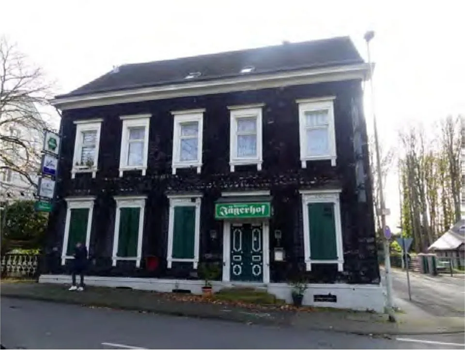 Zweistöckiges Wohn- und Geschäftshaus mit dunkler Fassade, weißen Fensterrahmen und grüner Tür, Schild 'Jägerhof', Altenhofer Str. 13, Solingen