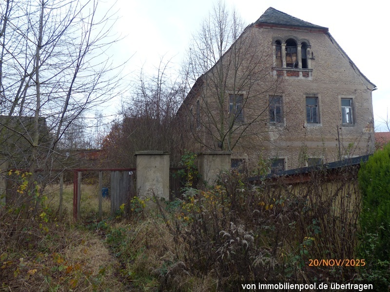 Zweistöckiges Gebäude mit verputzter Fassade, mehreren Fenstern und einem Satteldach, umgeben von trockenem Buschwerk und kahlen Bäumen, Alte Jeesewitzer Straße 7, Grimma