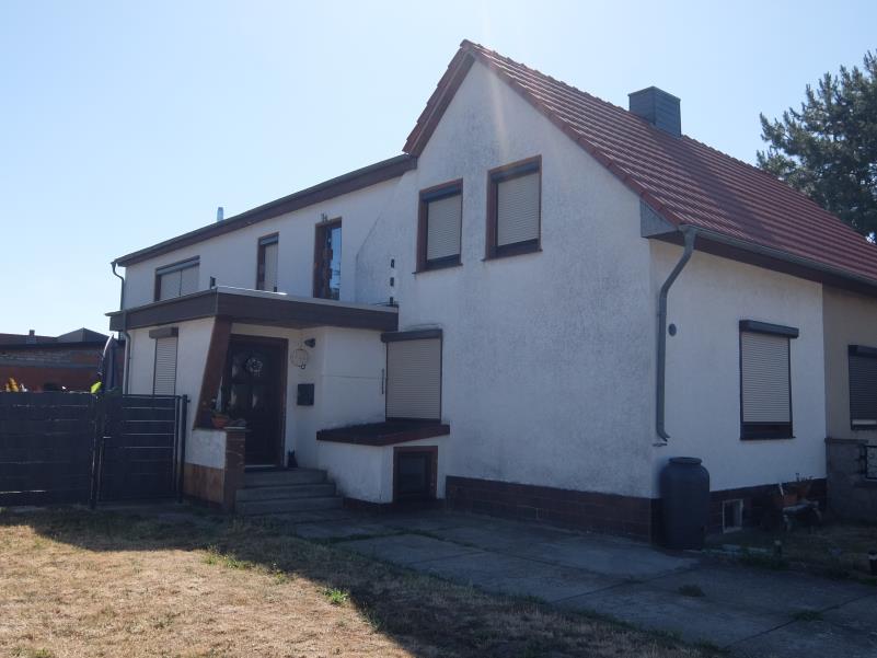 Vorderansicht einer Doppelhaushälfte in Blankenburg, Finkenweg 20, mit weiß verputzter Fassade, rotem Ziegeldach und Eingangsbereich mit Stufen