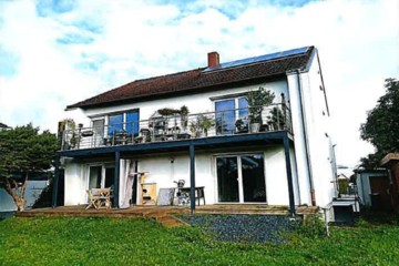 Zweistöckiges weißes Haus mit dunklem Dach, Balkon und Terrasse, umgeben von Grün, Germanenstr. 8, 89233 Neu-Ulm / Gerlenhofen
